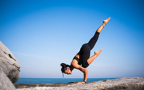 Low Angle View of Woman Relaxing on Beach Against Blue Sky thumbnail