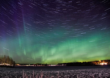 time-lapse photo of stars with aurora over the city thumbnail