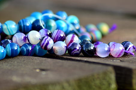 shallow focus photography of beaded white and purple necklace thumbnail