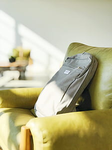 gray backpack on green leather sofa chair inside house on selective focus photography thumbnail