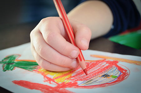 person holding red colored pencil in shallow focus photography thumbnail