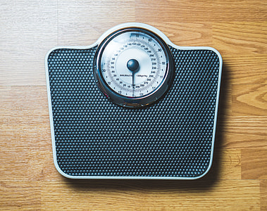 black analog bathroom scale on brown wooden surface thumbnail