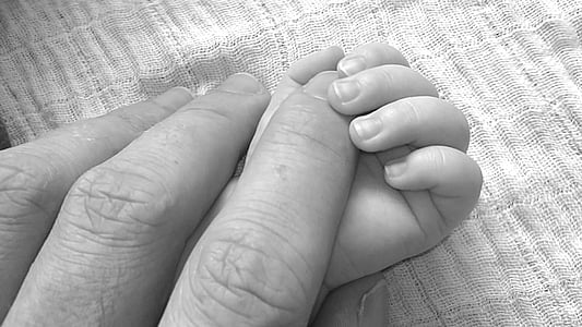 person hand over baby hand thumbnail
