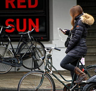 woman using smartphone while riding bicycle thumbnail