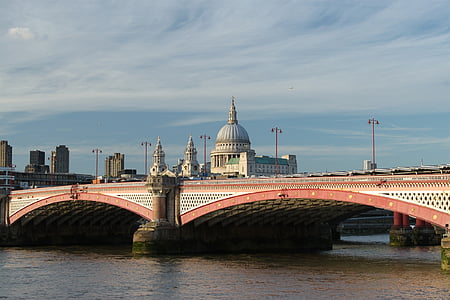 concrete dome building in front of bridge under white clouds thumbnail