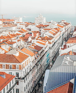 aerial view of concrete houses beside sea under white sky during daytime thumbnail