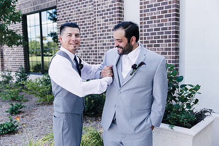 man holding men's arm near building during daytime thumbnail