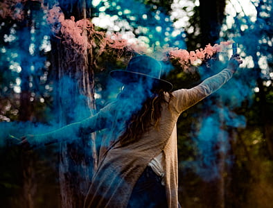 woman holding smoking device in the woods at daytime thumbnail