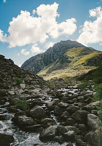 river surrounded by rocks near mountain range thumbnail