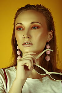 woman in white top holding sunglasses thumbnail
