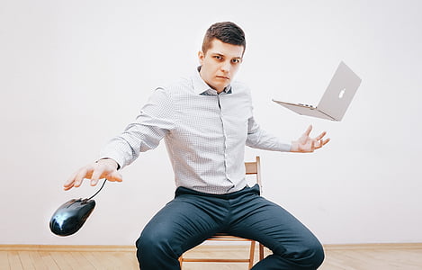 man in gray dress shirt holding laptop computer thumbnail