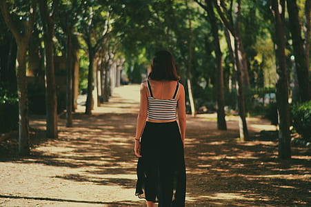 woman standing between trees thumbnail
