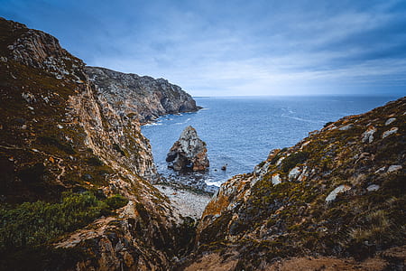 brown mountain near body of water thumbnail