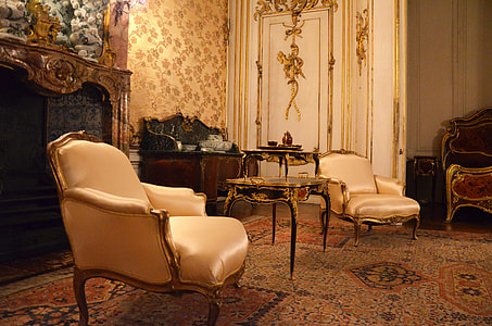 black wooden side table in the middle of two white satin sofa chairs thumbnail