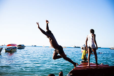 man about to jump on boat towards to body of water thumbnail