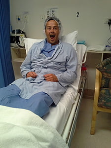 man opening his mouth while sitting on bed thumbnail
