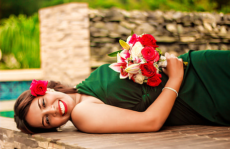 woman in green dress laying down on brown wooden surface during daytime thumbnail