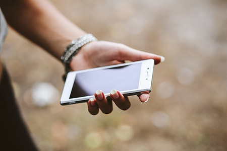 Young woman holding the white mobile phone thumbnail