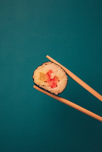 person holding chopsticks with sushi thumbnail