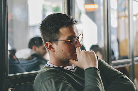 man sitting learning against the wall thumbnail
