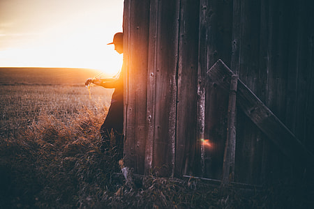 man standing near brown and black wall during daytime thumbnail