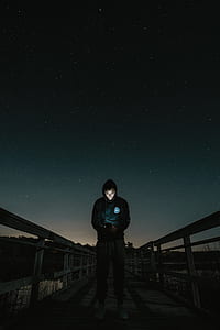 photo of man in black hoodie standing on bridge thumbnail