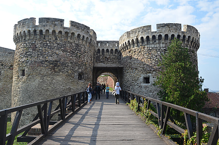 people walking on bridge in front of castle thumbnail