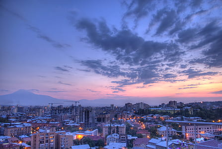 aerial photography of city under grey clouds during sunset thumbnail