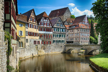 row of colorful houses beside creek with bridge thumbnail