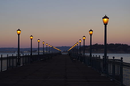 wooden deck with black metal frame rails and lighted lamp post thumbnail
