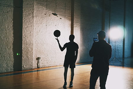 man taking photo of person playing basketball thumbnail
