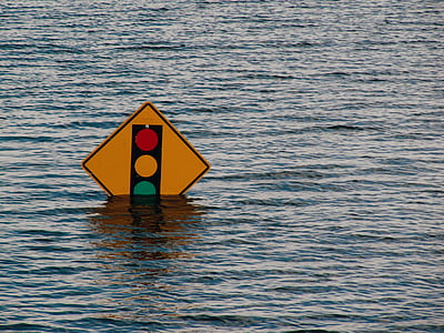 yellow road signage surrounded by body of water thumbnail