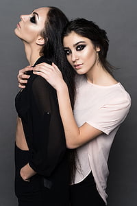 photograph of two woman wearing black dress shirt and white shirts thumbnail