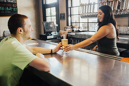Woman Handing Glass Cap to Man in Green T-shirt thumbnail