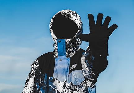 man wearing white, blue, and black button-up hoodie and black glove thumbnail
