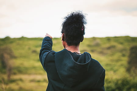 Man Pointing on Grass Field thumbnail