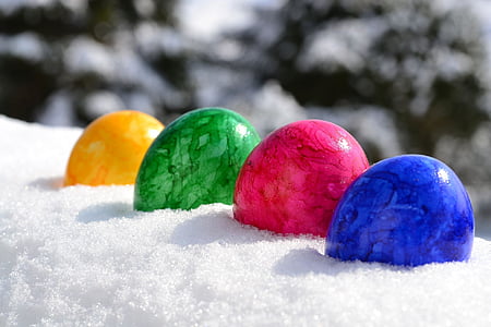 shallow focus photography of yellow, green, pink, and blue stone fragments on snow thumbnail