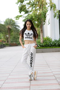 black haired woman wearing Adidas crop-top and sweatpants with pair of silver platform sneakers thumbnail