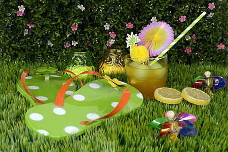 flip flops with glass and lemons on grass thumbnail