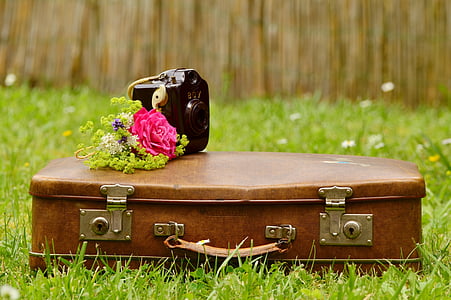 black camera on top of brown leather suitcase thumbnail