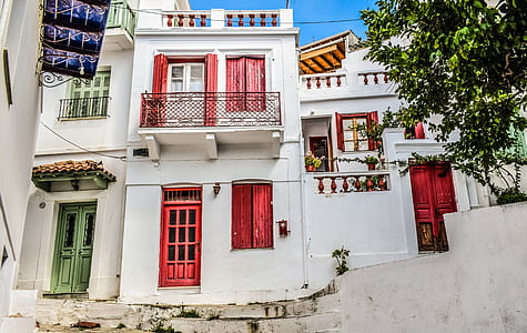 white and red concrete 2-story house beside green leaf plant at daytime thumbnail