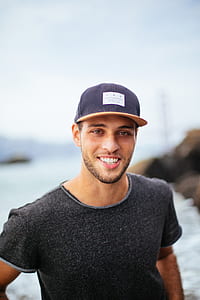 shallow focus photography of man in black crew-neck shirt showing smile thumbnail