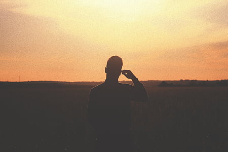silhouette photography of person under yellow sky thumbnail