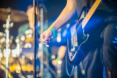 person holding black electric guitar outdoors thumbnail