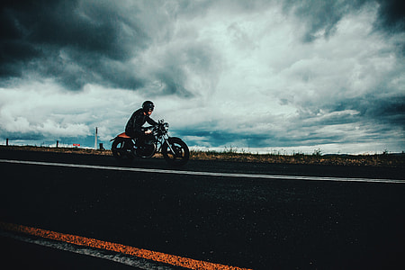 Moody shot of a man on the road riding a motorbike thumbnail