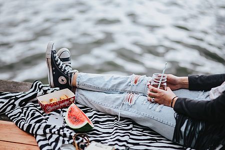Blonde woman having a healthy snack at the wooden pier thumbnail
