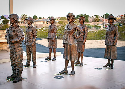 men and women standing statues near post during day thumbnail