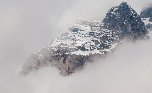 brown snowy mountain covered with white mist during daytime thumbnail