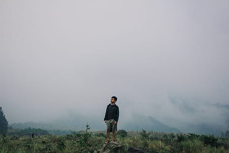 man standing on rock with foggy background thumbnail
