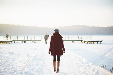 woman wearing red coat and brown leggings walking during winter thumbnail